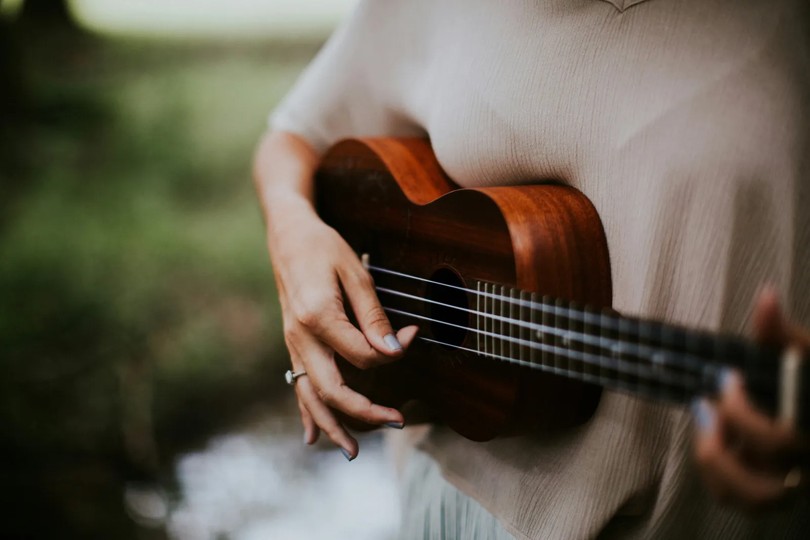 Hands playing a ukulele, unhurried and unpractised
